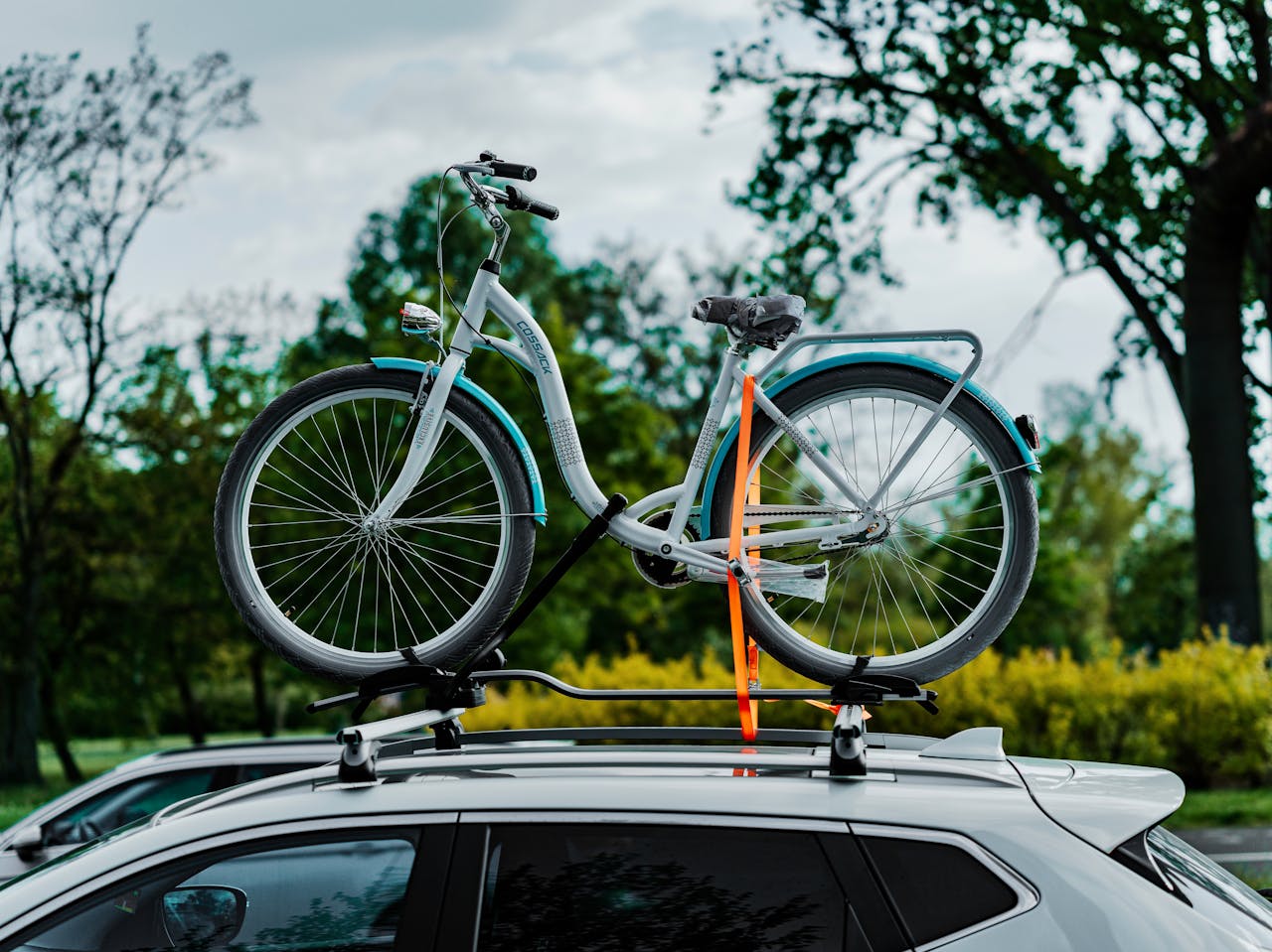 Bicicletă montată pe bare transversale pe acoperișul unei mașini