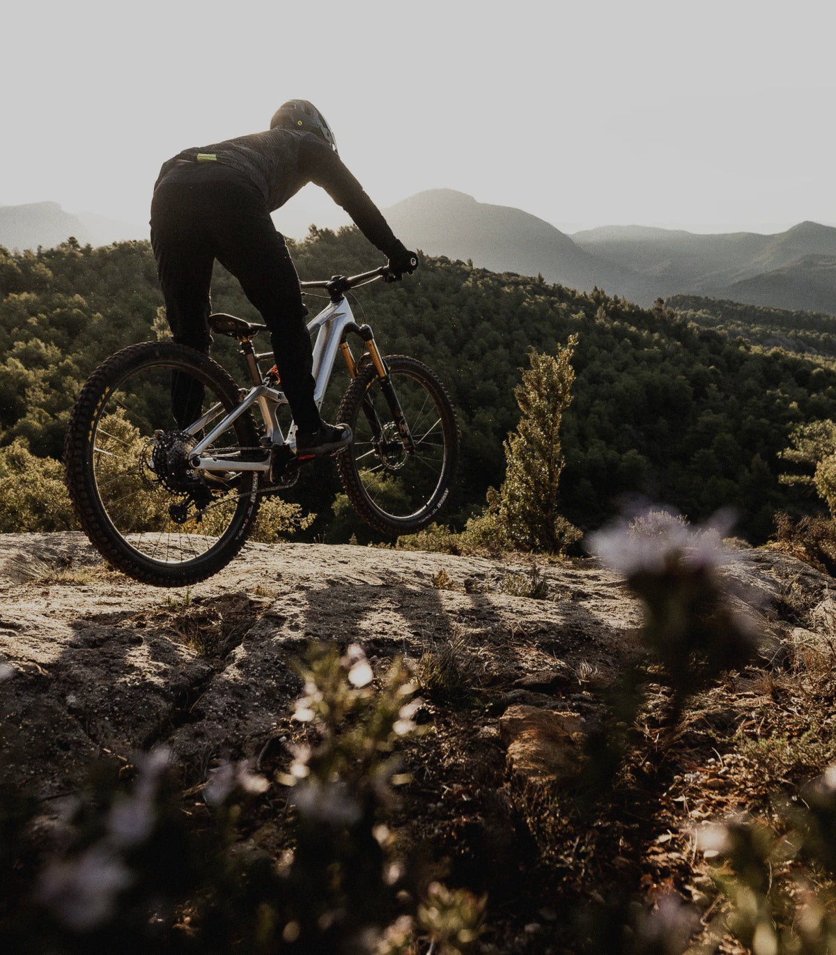 Biciclist pe o bicicletă de munte full-suspension, pe un traseu stâncos